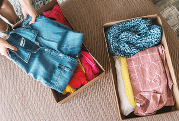 Clothing being folded and being packed into boxes ready for donation 