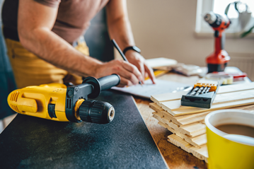 Man making home adaptations using power tool 