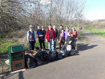 A group of volunteers standing outside with tools and equipment